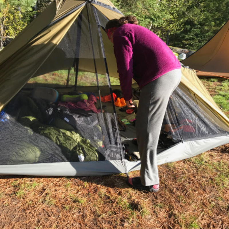 person zips up full height zipper door on Cimarron full nest