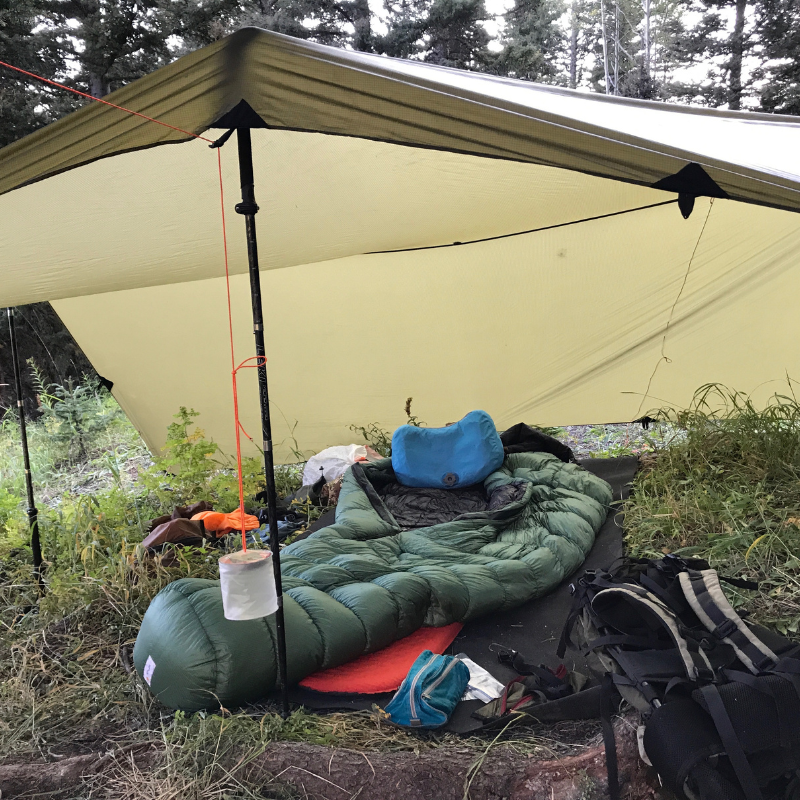 a sleeping pad and gear on a Matty ground mat inside a shelter