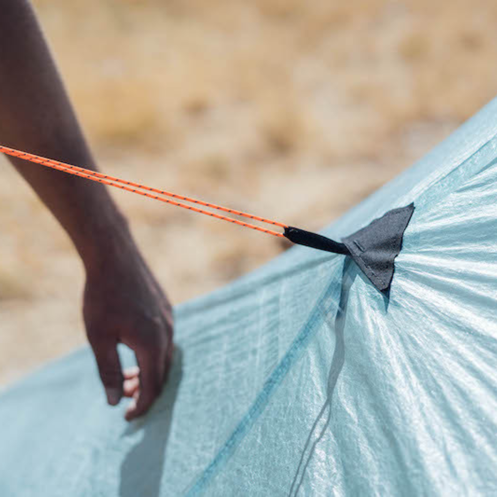  person adjusts the tension on Reinforced tent guy outs 