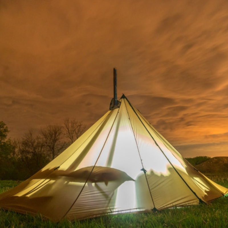 light shines inside a Redcliff Light tent, the silhouette of cots visible inside