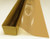 A roll of Tan-colored window film is partially unrolled from a cardboard box.
