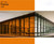 This image showcases a modern glass office building with a portion of its windows covered in Flame window film. The Flame tint creates a striking contrast, casting an appealing hue over the interior space on the left side, while the right side remains untinted and clear. The film enhances both aesthetics and functionality, offering reduced glare and a distinct visual appeal. Above the building image, there is a solid Flame color block labeled "60” Wide Flame 2800," indicating the film’s width and product code.
