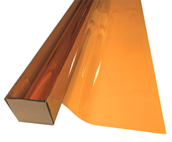 A roll of Mandarin Amber-colored window film is partially unrolled from a cardboard box.