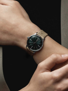 The Junghans 27/3343.00 Meister Damen Automatic Green Dial is a ladies' dress watch. It has a green dial with index markings and luminescent hands. The watch is made with a stainless steel case, a 33.1 mm case size, and a closed case back. It has a beige leather strap, a pin buckle, and a sunray finish. The watch is powered by the J840.1 automatic movement, which has 25 jewels and a 38-hour power reserve. The movement's operation can be observed through a transparent escapement. The Junghans 27/3343.00 Meister Damen Automatic Green Dial is a ladies' dress watch. It has a green dial with index markings and luminescent hands. The watch is made with a stainless steel case, a 33.1 mm case size, and a closed case back. It has a beige leather strap, a pin buckle, and a sunray finish. The watch is powered by the J840.1 automatic movement, which has 25 jewels and a 38-hour power reserve. The movement's operation can be observed through a transparent escapement.