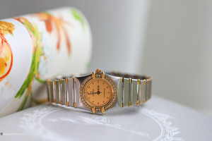 A timeless symbol of precision and elegance, the Omega Constellation Ladies Watch blends classic design with luxurious materials. Crafted from 18k yellow gold and stainless steel, this iconic two-tone wristwatch features a brilliant diamond bezel set with high-quality single-cut diamonds that catch the light beautifully. A timeless symbol of precision and elegance, the Omega Constellation Ladies Watch blends classic design with luxurious materials. Crafted from 18k yellow gold and stainless steel, this iconic two-tone wristwatch features a brilliant diamond bezel set with high-quality single-cut diamonds that catch the light beautifully.