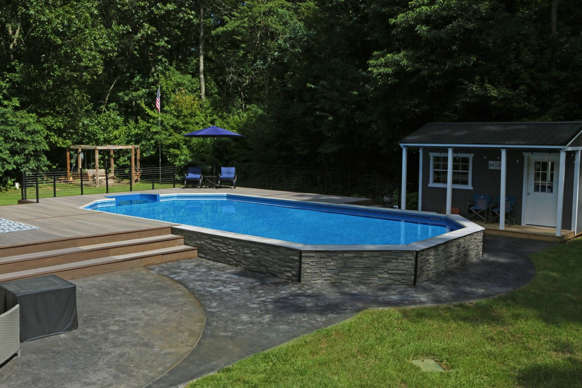 Semi-inground Hydrosphere Series pool finished with stacked stone veneer