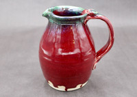 Ruby Red Pitcher with copper rim, roughly 6 inches wide (with handle) by 6.5 inches tall, (SK7857)