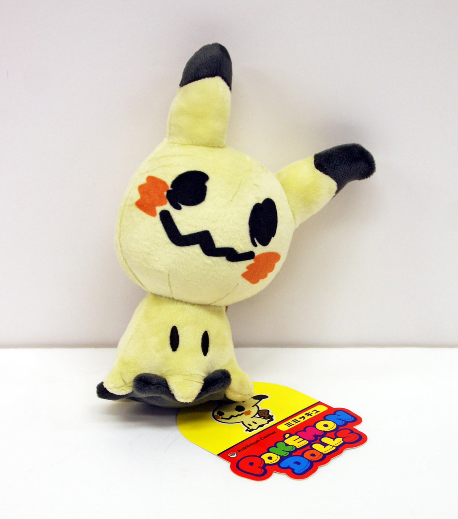 A Mimikyu plush leans against the wall.