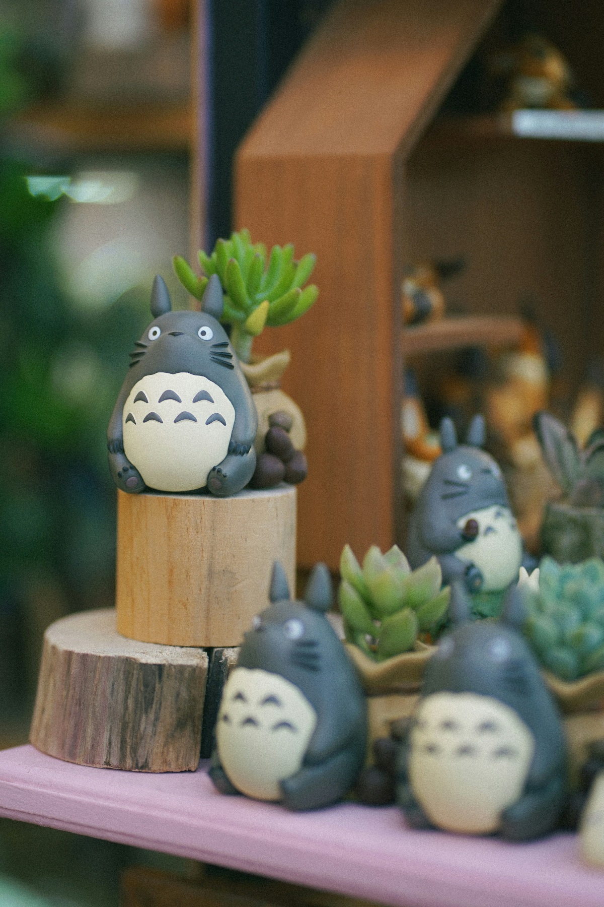 Plastic Totoro figures lined up on mini fake logs