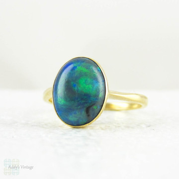Art Nouveau Opal Doublet Ring, Black Opal Cabochon Bezel Set 18 Carat Yellow Gold Solitaire Setting, Circa 1910s.