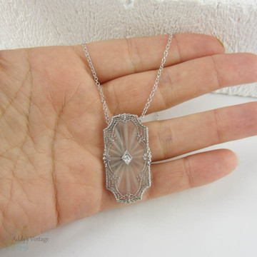 Art Deco Pendant. Camphor Glass, Diamond and White Gold Filigree Necklace. Lacey Floral Filigree with Milgrain Detail, Circa 1920s.