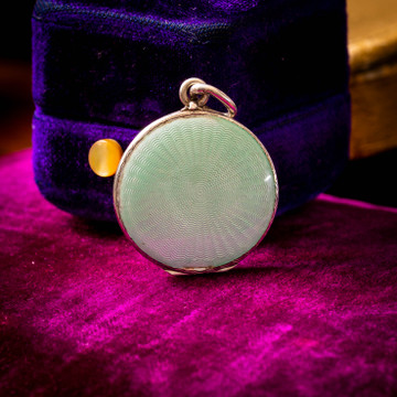 the pink that looks like it's on the locket is a reflection of the box it's sitting on