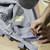 Denim tailor marking jeans for a professional waist reduction at Williamsburg Garment Company in Brooklyn, NYC.
