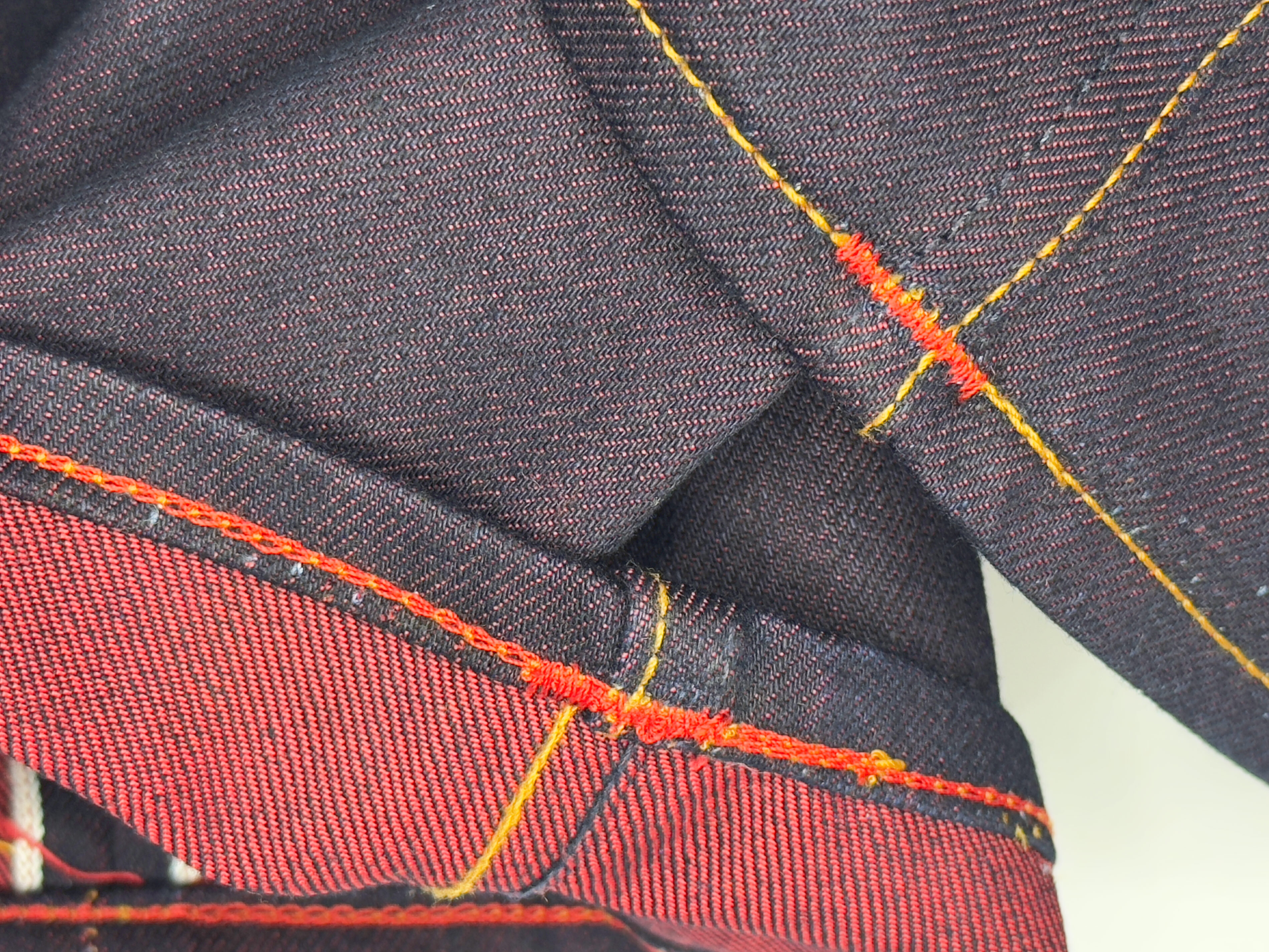 After hemming, a view of the red weft of Gustin jeans shows clean chain-stitching and properly sewn bar tacks on the inseam, sewn by Williamsburg Garment Company.