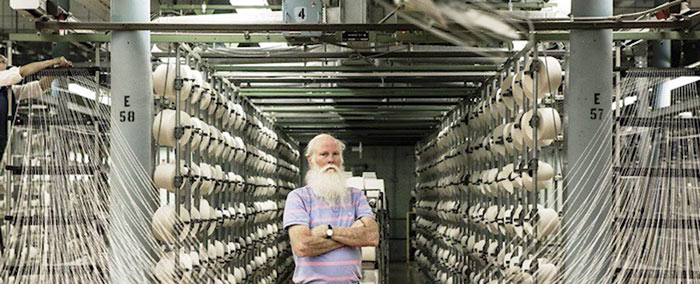 A man standing inside the Cone White Oak denim mill.