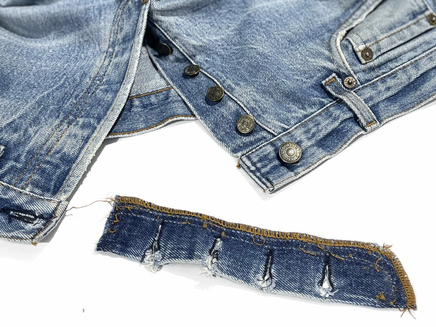 Levi’s button-fly jeans post-repair by Williamsburg Garment Company. Top view showcases pristine sewing, mirroring factory quality. Original button fly panel with ripped torn buttonholes visible.