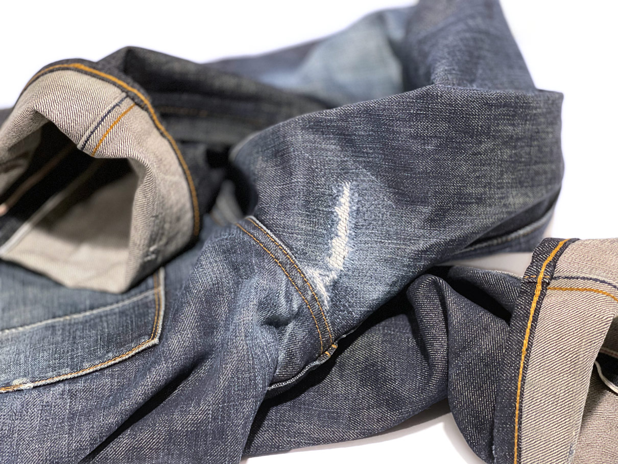 Close-up of denim repair work in the crotch of jeans