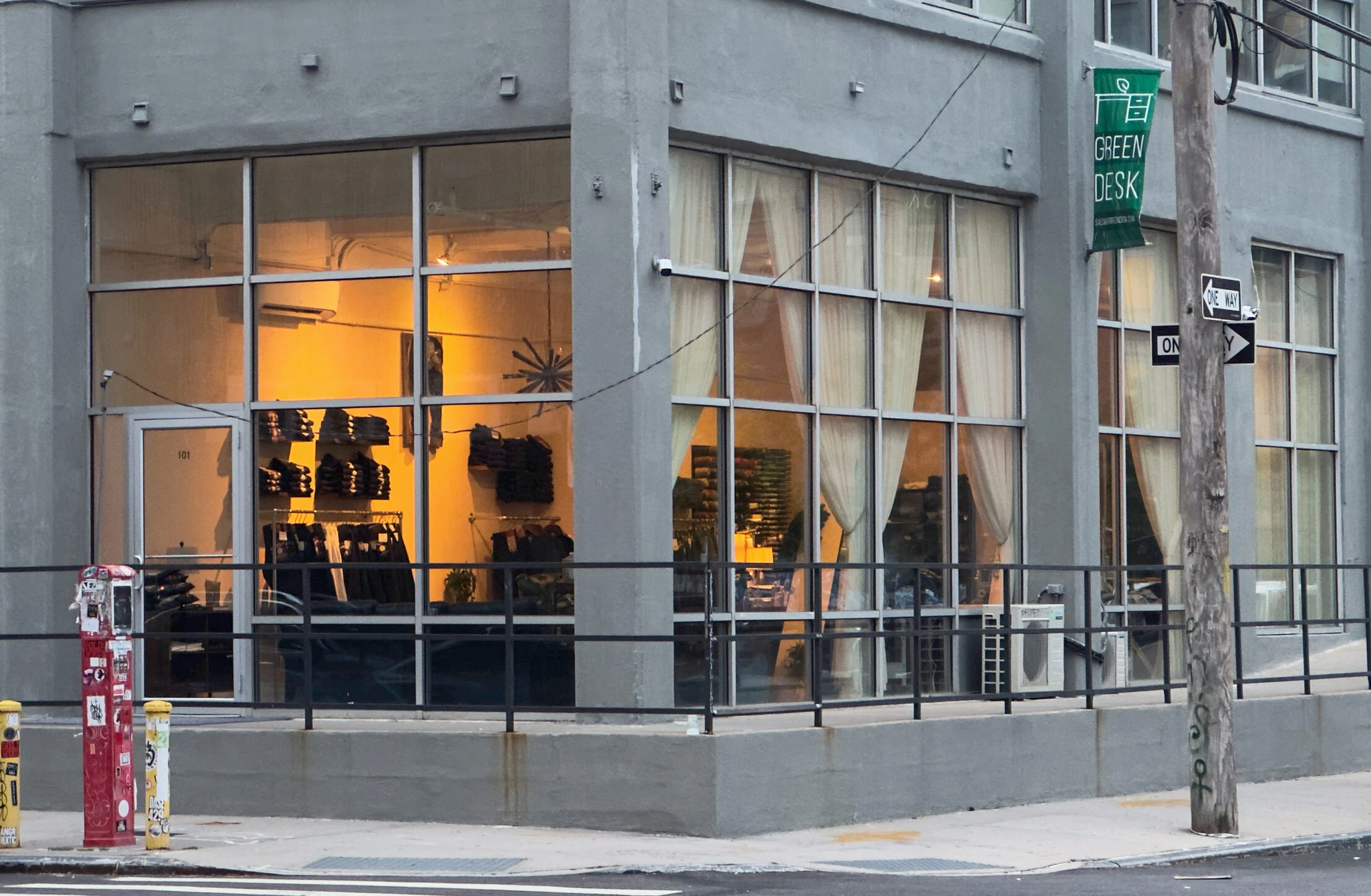 Williamsburg Garment Company storefront with jeans visible through tall windows and two yellow rectangles marking window signage areas.