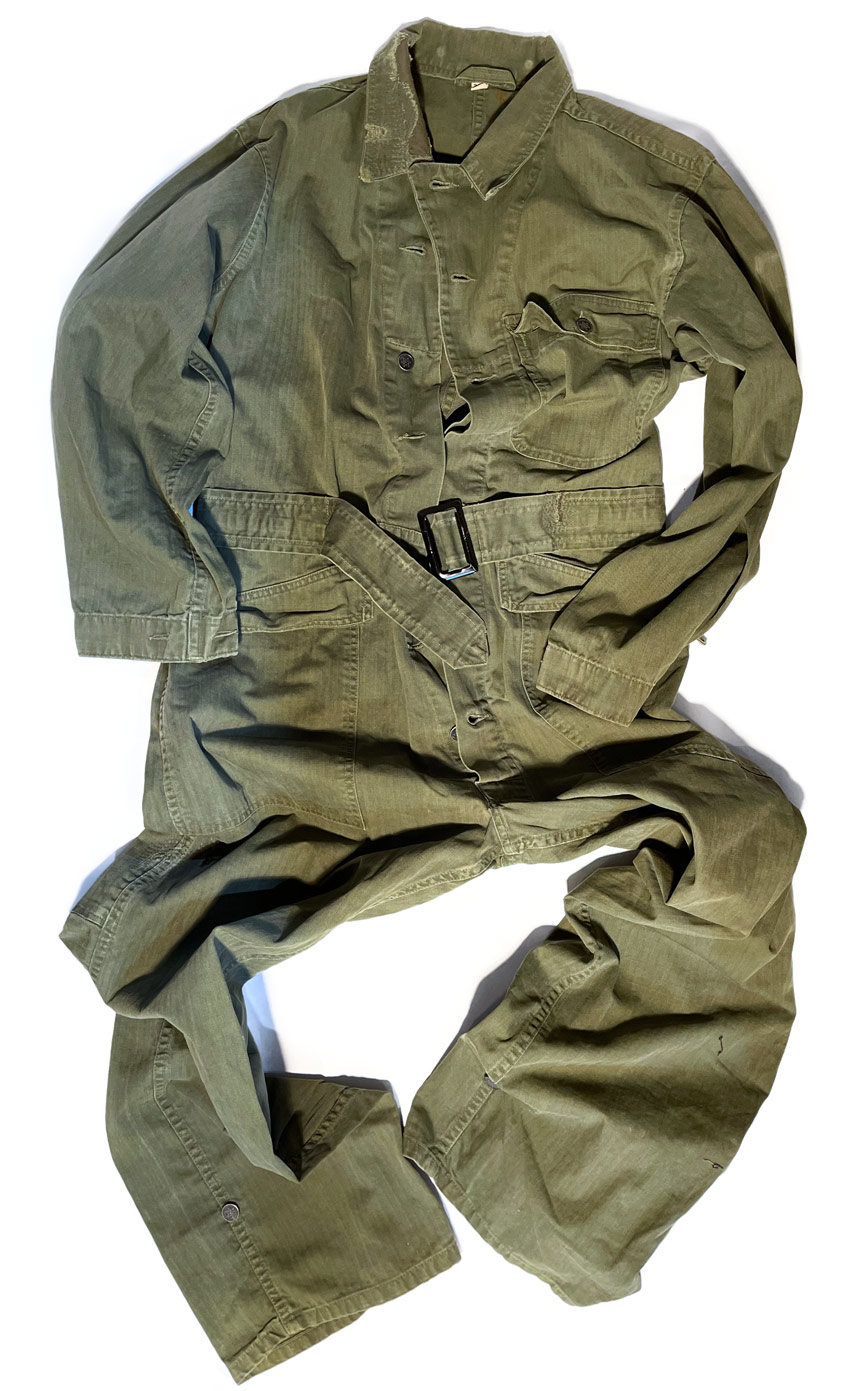 Army green coveralls with a large hole in the collar and other small rips and tears repaired by Williamsburg Garment Company denim repair services