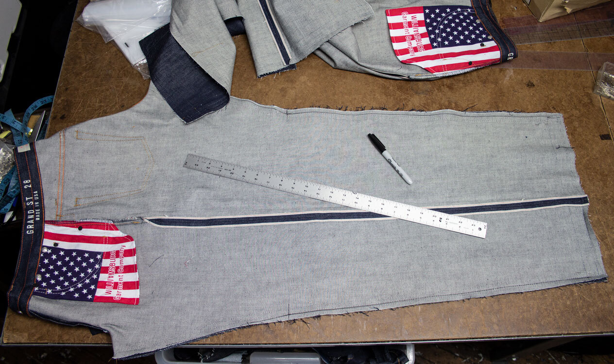 Jeans with flat-felled inseam opened during tapering process on tailoring table