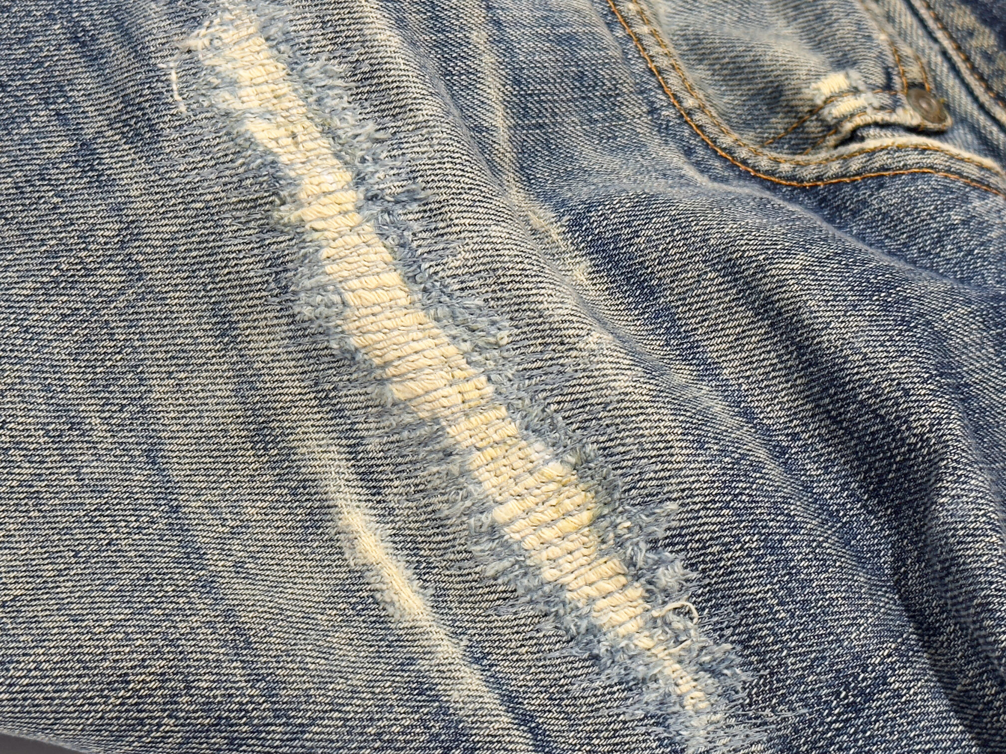 Close-up of Nudie jean repair stitching by Williamsburg Garment Company on a whisker tear.