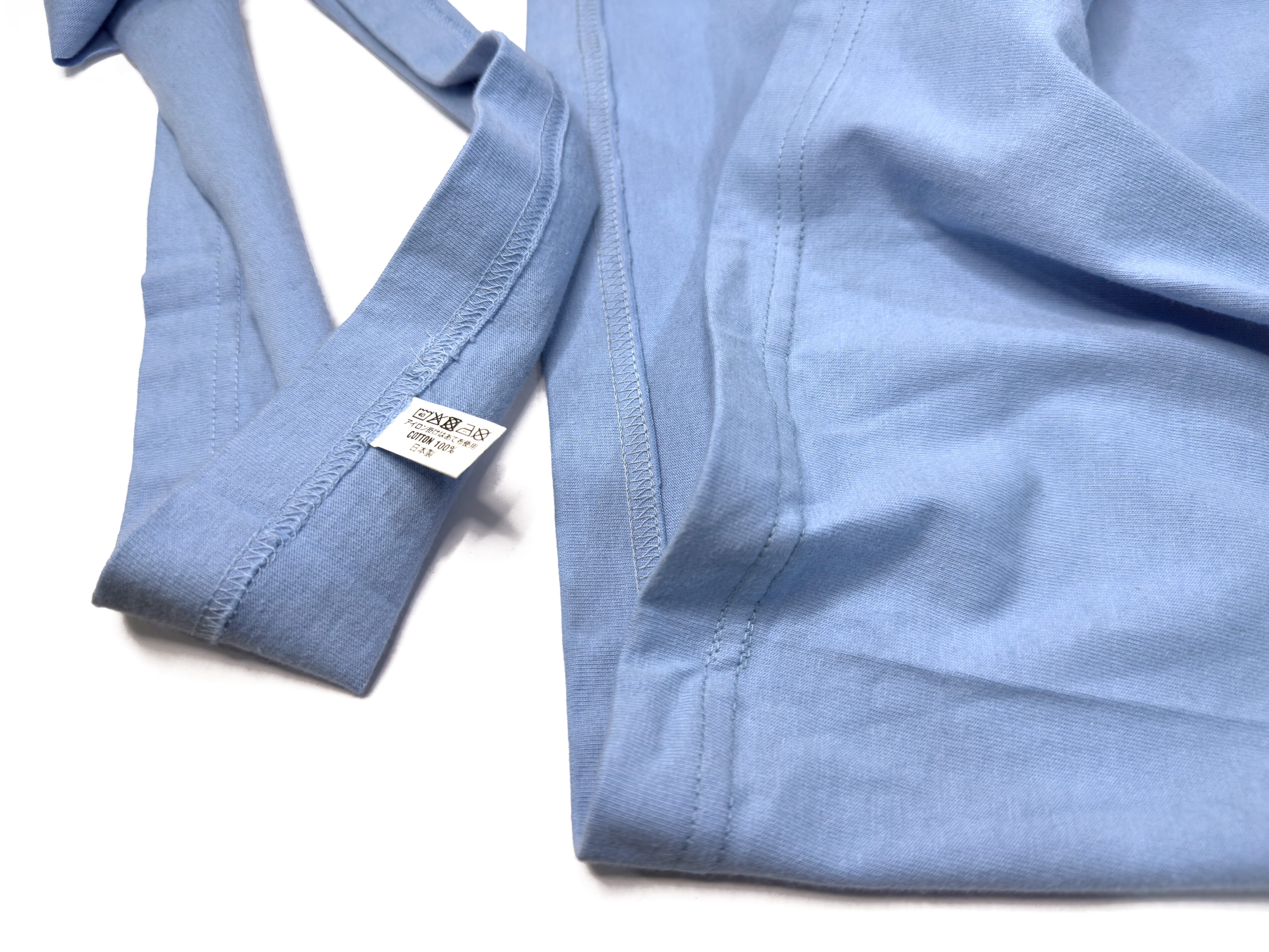 Close-up view of a professionally hemmed Iron Heart t-shirt, showing shortened hem detail and removed fabric, tailored by Williamsburg Garment Company.