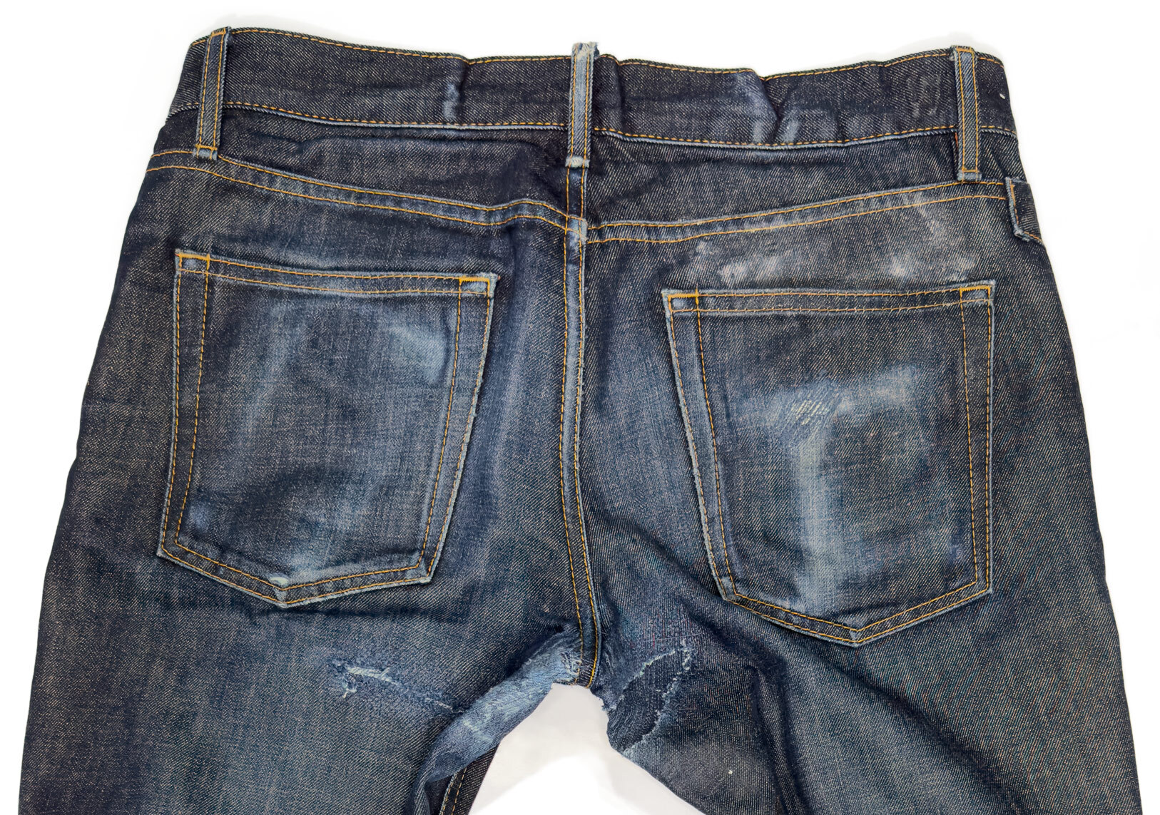 Close-up of the denim repair on a pair of vintage Williamsburg jeans showing damaged fixes on the rear pockets, crotch blowout repair stitching, and raw denim fades.