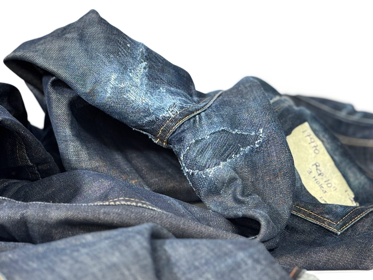 Close-up of crotch blowout repair on Williamsburg Garment Company jeans with a darker denim patch and repair stitching that stretches with the fabric.