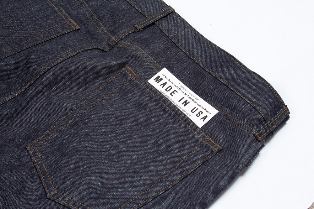 Close-up of American made raw denim jeans with unbranded rear pocket & Made in USA tag