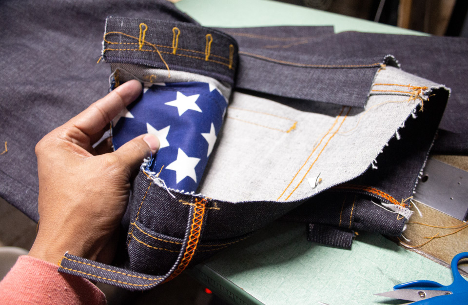 Made-to-order button-fly raw denim jeans in sewing process