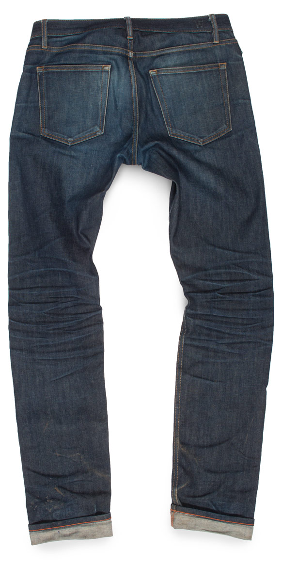 The rear side of American-made faded raw denim jeans produced in Cone White Oak stretch selvedge.