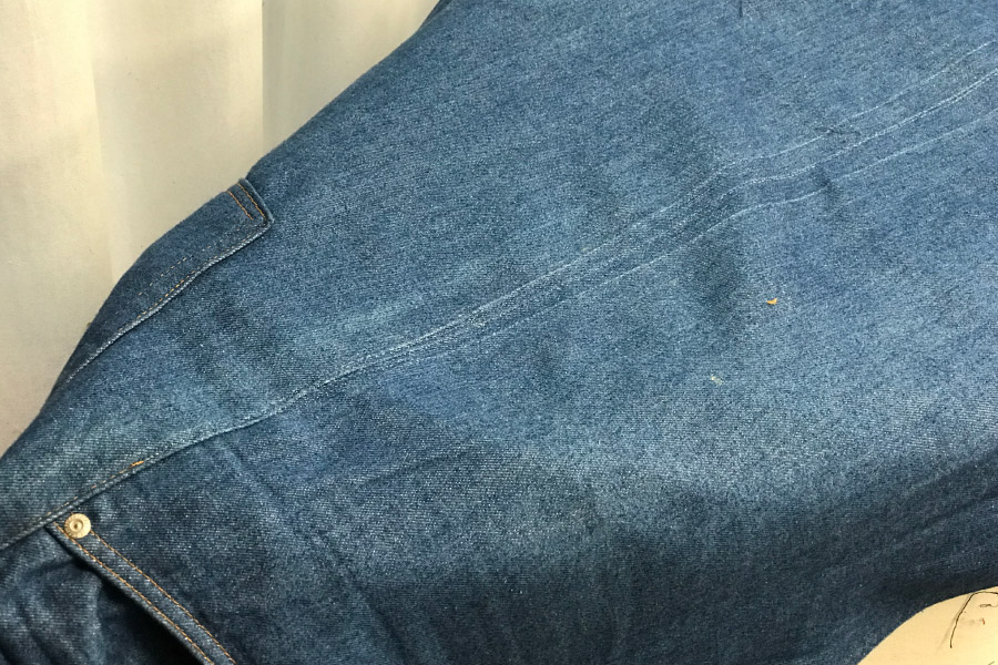 The outseams are pressed flat. Holes can be seen from the prior tailoring work.