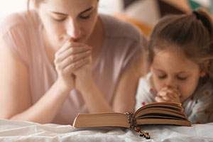 mother and daughter praying