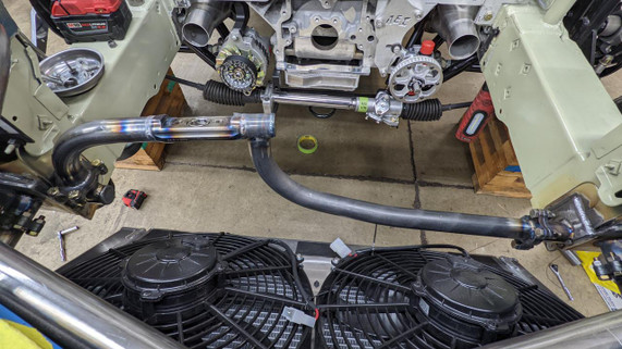 Scram Speed Quick Disconnect 1.25 Tube Chassis Flanges, viewed from above showing metal flanges connected to a vehicle chassis with surrounding tools and mechanical components. 