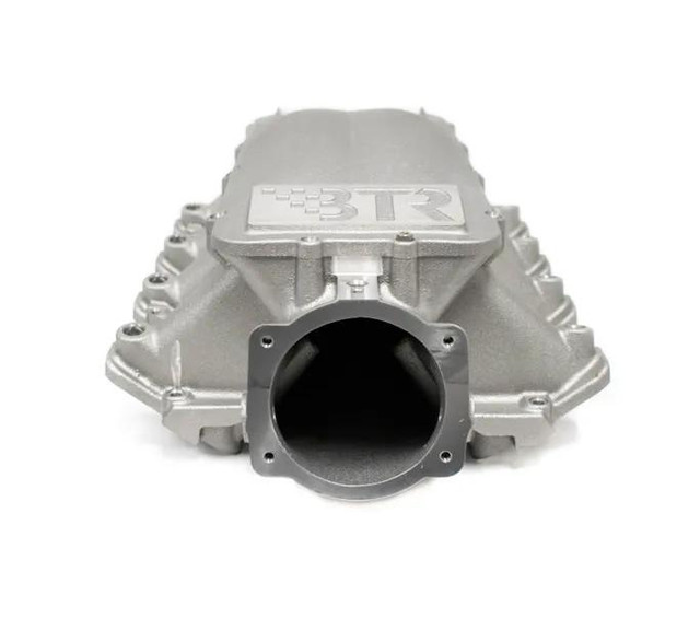 BTR EQUALIZER 1 INTAKE MANIFOLD - CATHEDRAL PORT - IMA-01, a silver polished automotive intake manifold with a large central port and the BTR logo on top. BTR EQUALIZER 1 INTAKE MANIFOLD - CATHEDRAL PORT - IMA-01, a silver polished automotive intake manifold with a large central port and the BTR logo on top.
