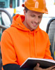 A bright orange and black water-resistant fleece hoodie with a hood, worn by a person in safety gear, reading a book.