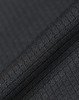 A close-up of textured black fabric, showcasing a sustainable jacquard knit pattern. Featuring a subtle sheen, it has a fabric brand logo.