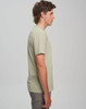 A light green men's premium cotton short-sleeve t-shirt displayed on a model from the side. The shirt has a logo.