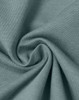 A close-up of a soft, lightweight, textured fabric in a muted teal colour, showcasing its smooth surface and drape.