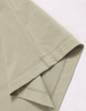 A close-up of a light green premium cotton T-shirt featuring short sleeves and neat stitching.