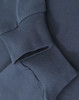 A close-up of navy blue cotton tee shirt cuffs with ribbed detailing, featuring a logo on the fabric.