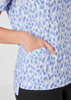 A light blue tunic with a stardust print, featuring a side pocket and short sleeves.
