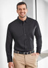 A black men's long sleeve shirt with a button-down front and a pocket, paired with beige trousers.