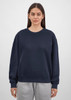 A navy crew sweatshirt for women featuring a relaxed fit, paired with grey sweatpants. It has a logo on the front.