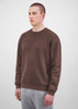 A brown men's crew sweatshirt on a model, featuring long sleeves and a relaxed fit.