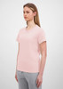 A light pink women's short sleeve tee displayed on a model with straight hair, paired with grey bottoms.