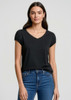 A woman wearing a black short sleeve V-neck t-shirt paired with blue jeans, featuring a subtle logo.
