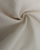 A close-up of a light beige cotton blend fabric, showcasing its soft texture and woven pattern.