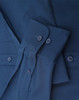 A navy blue long-sleeve cotton blend shirt with buttons and a folded sleeve detail. It features a logo.