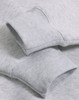 Close-up of a light grey fleece oversized hoodie featuring ribbed cuffs and a soft texture.